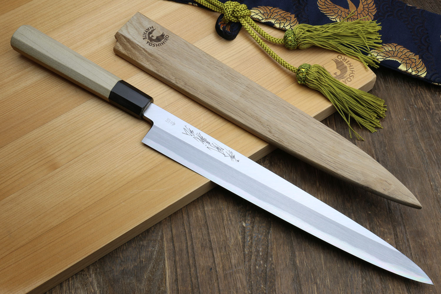 Japanese sashimi knife with silver steel blade and magnolia wood handle, black bolster