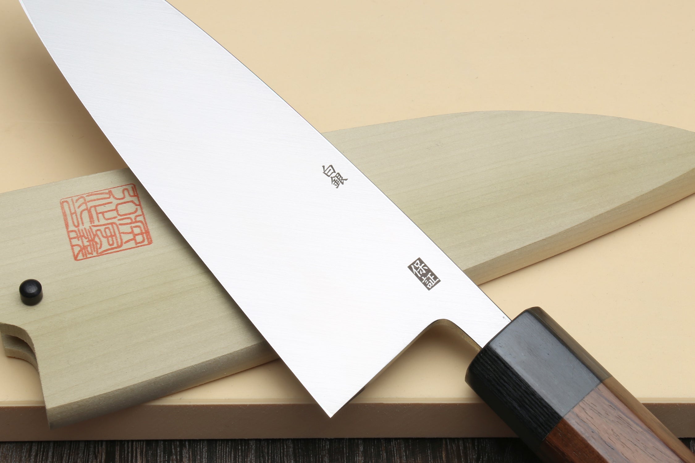 Deba fish fillet knife top view, white blade with etched marks and rosewood handle