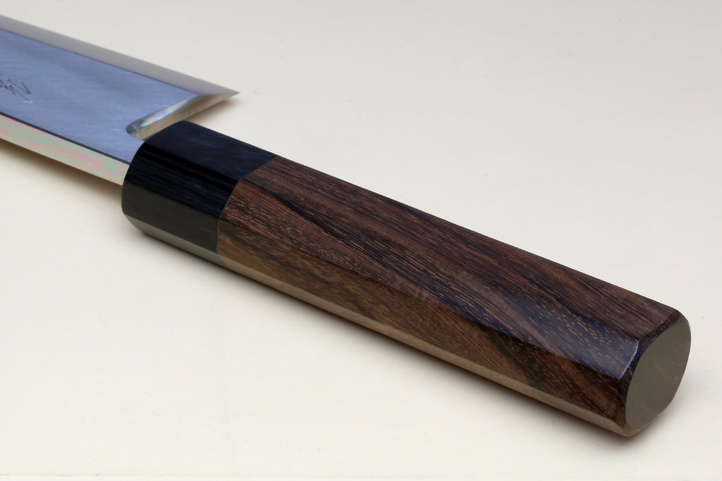 Deba knife handle close-up: dark bolster and brown rosewood scales on a white blade