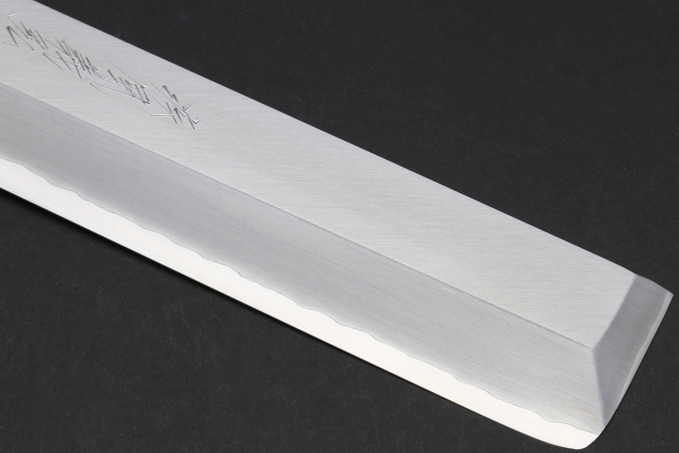 Japanese chef knife blade edge close-up with pale polished finish