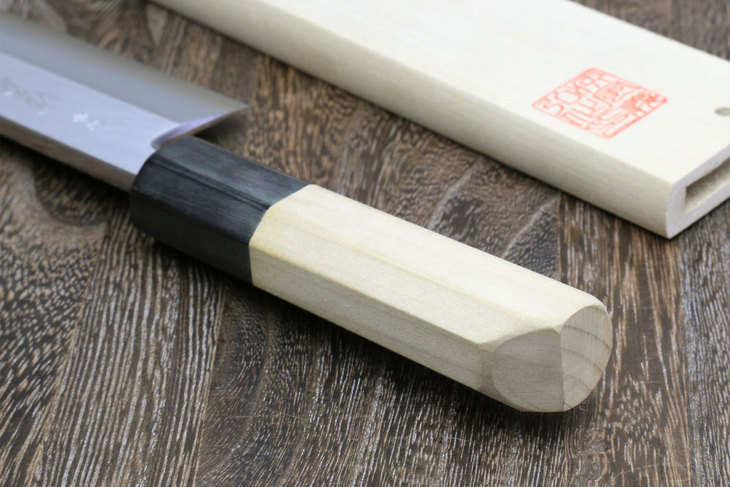 Eel filet knife with pale handle and black bolster, close-up view