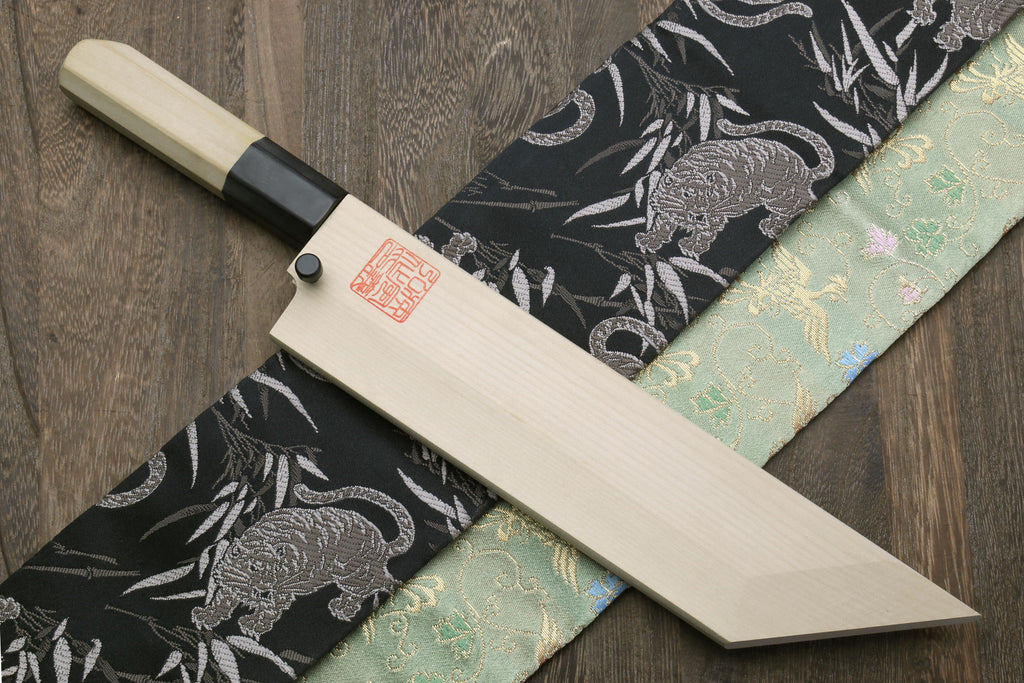 Eel filet knife with light wooden sheath and blade on patterned fabric