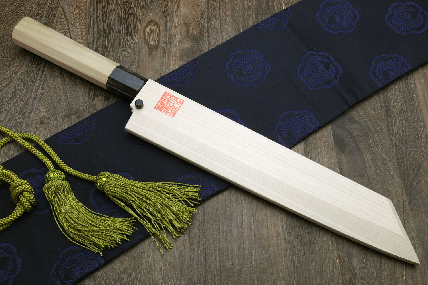 Japanese chef knife with wooden sheath and magnolia handle, green tassel cord.