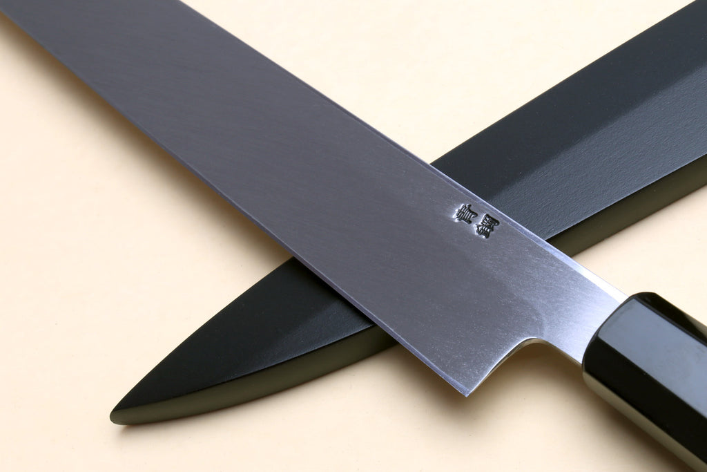Yanagi sushi knife with mirror-finished blade and dark handle, stamped emblem