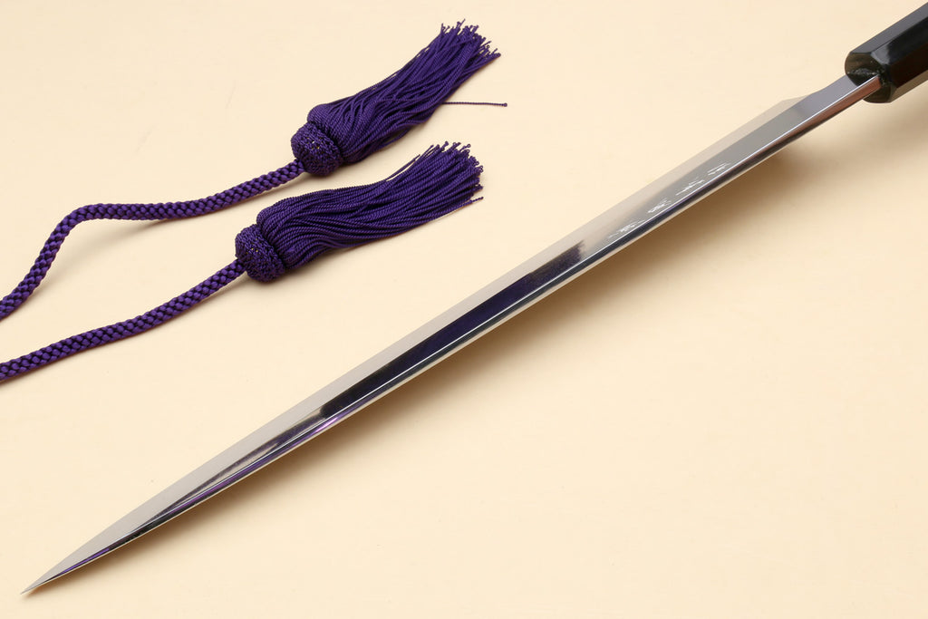 Yanagi sushi knife with mirror-finished blade, dark handle, and purple cord tassels