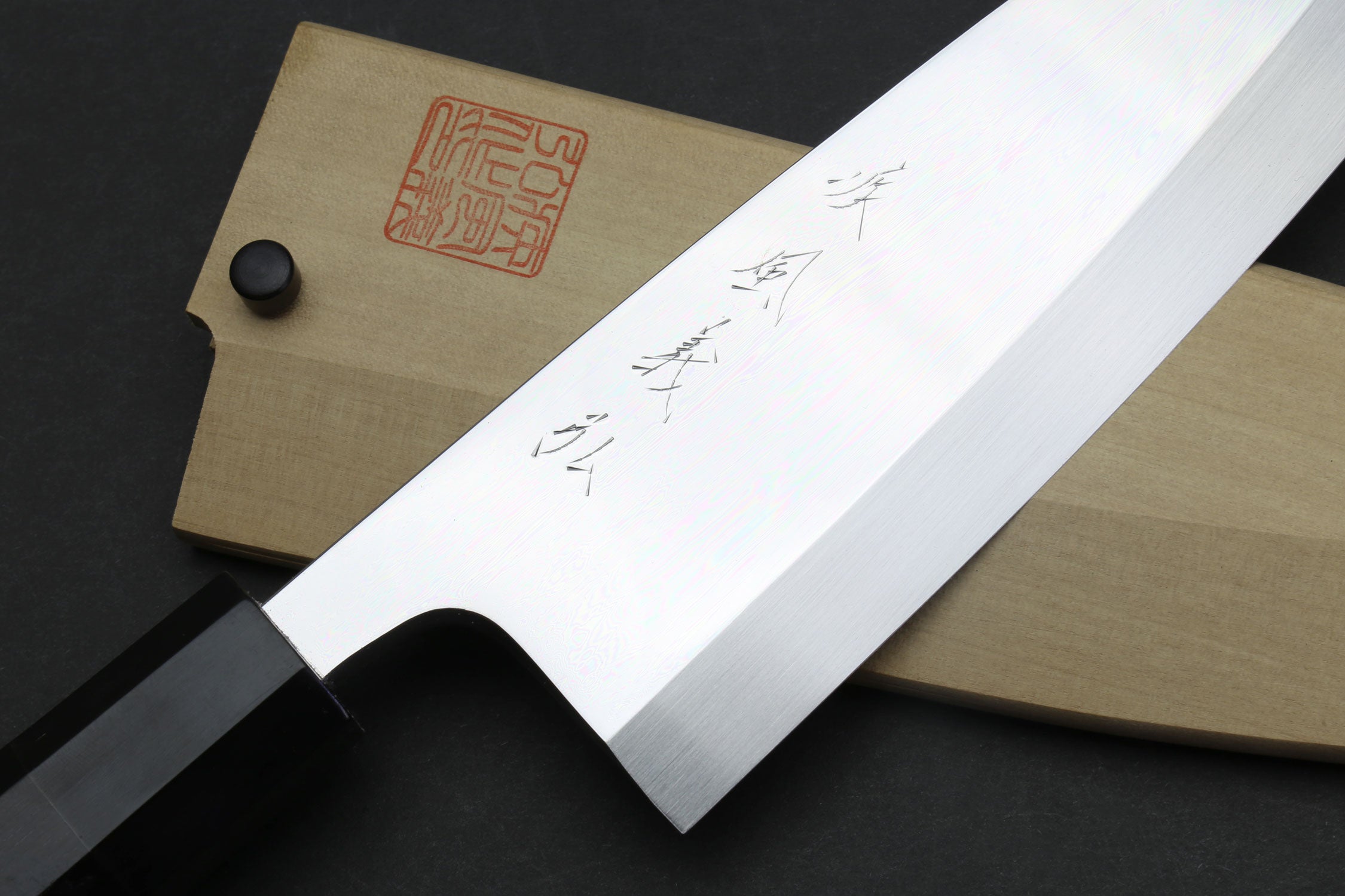 Deba sushi fillet knife with mirror blade markings and light wooden saya