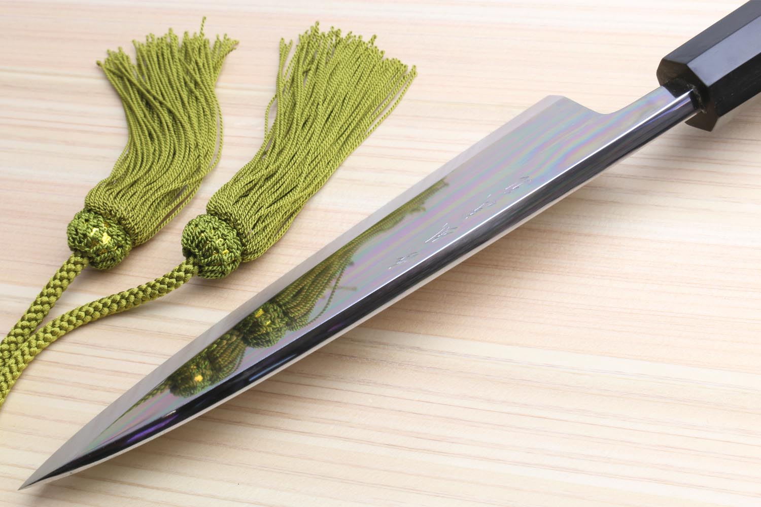 Deba sushi fillet knife with mirror blade and green braided cord tied near handle