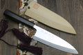 Mirror-finished deba sushi fillet knife with dark handle and light wooden saya