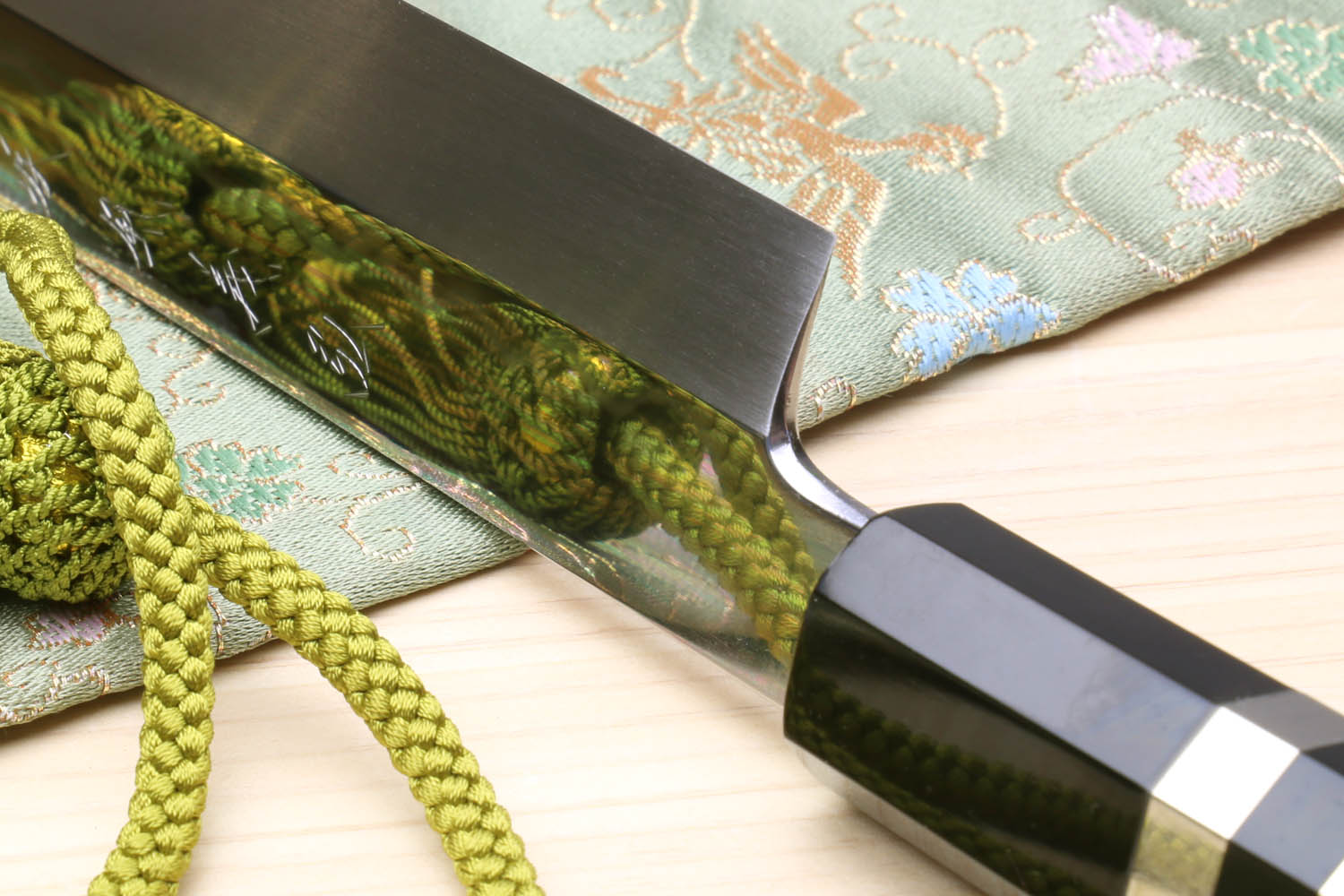 Japanese sushi knife with mirror-finished blade and black-and-ivory checkered handle