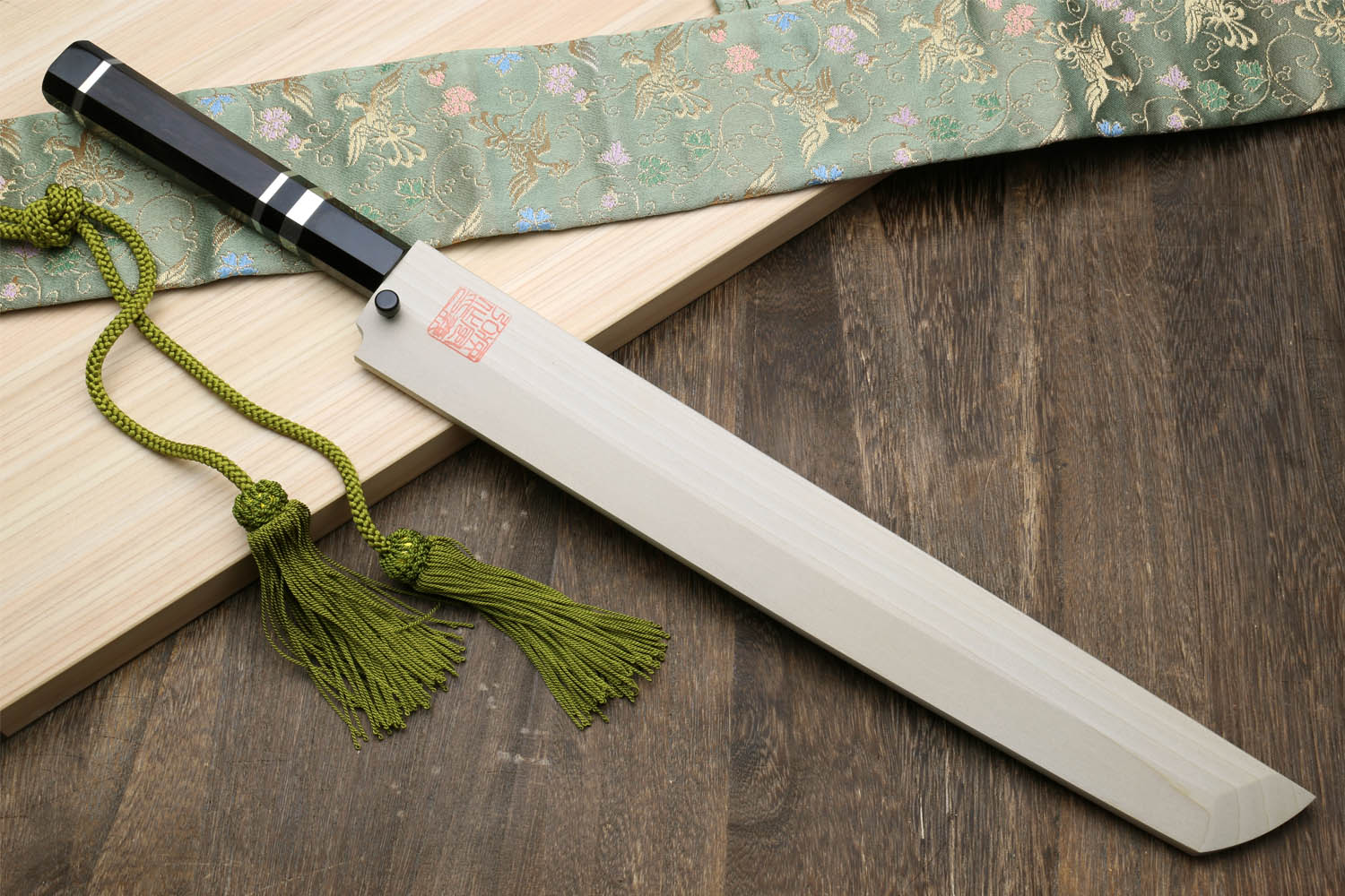 Japanese sashimi knife with pale handle, dark cap, and long silver blade