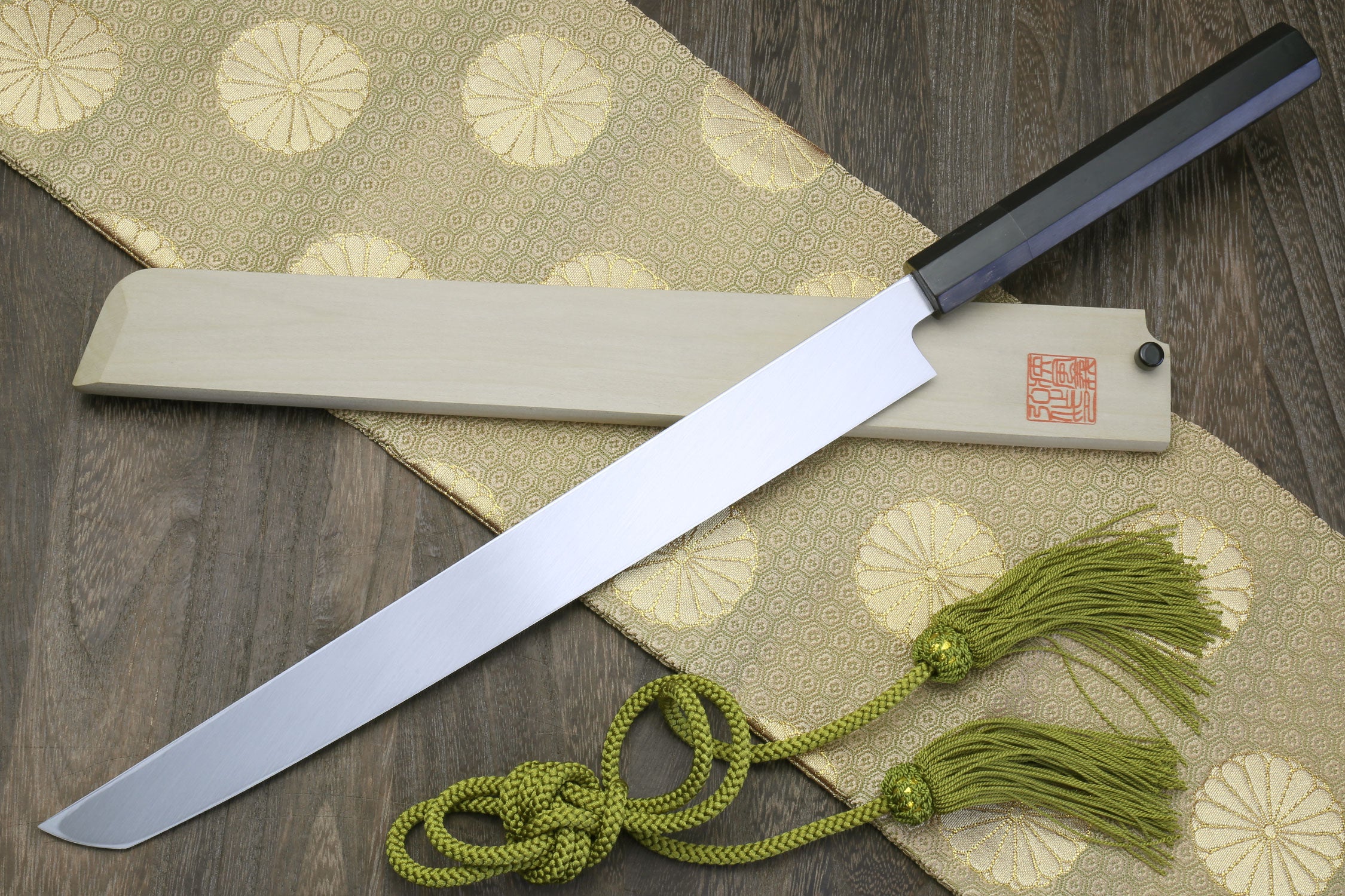 Sushi sashimi knife with long mirror-finished blade and dark ebony handle, green cord tied.
