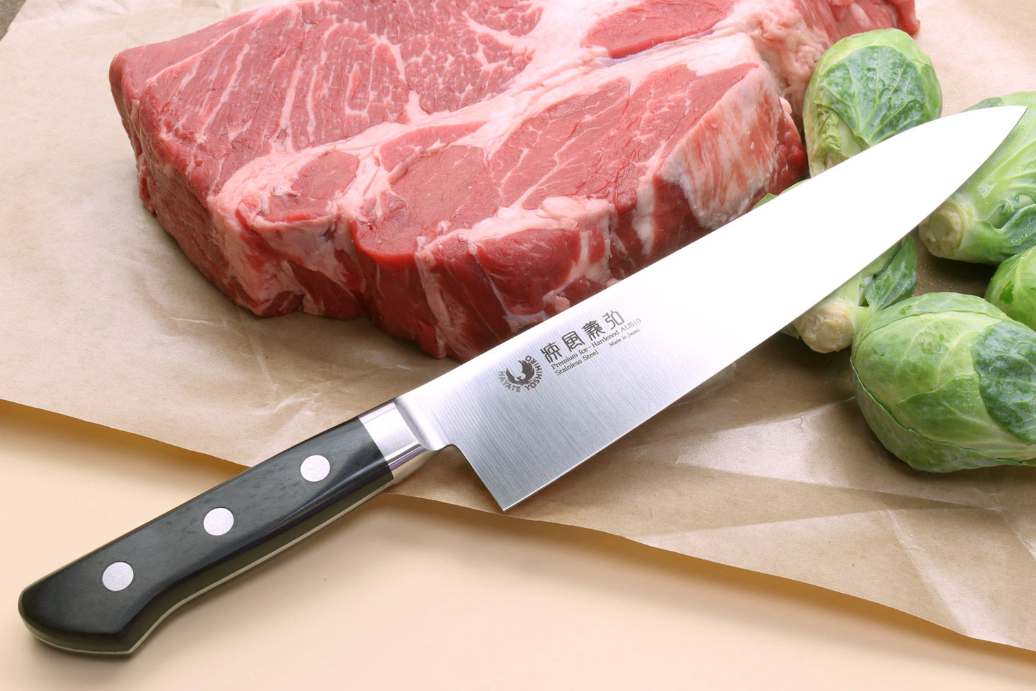 Stain-resistant gyuto knife with black handle and silver blade, angled view