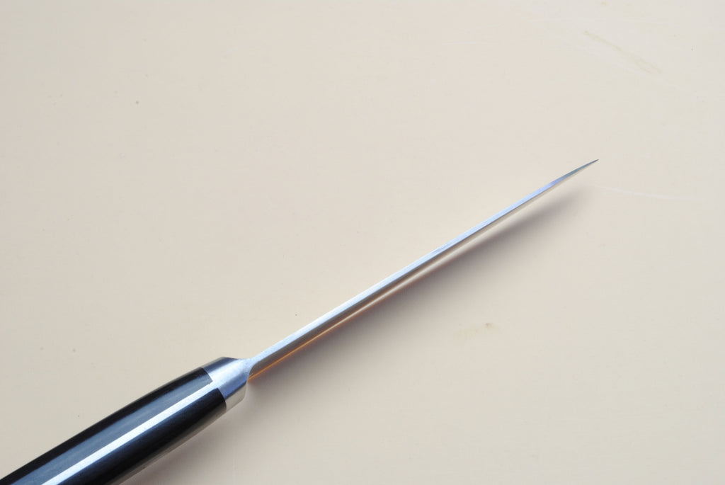 Petty knife tip with dark handle and polished steel blade