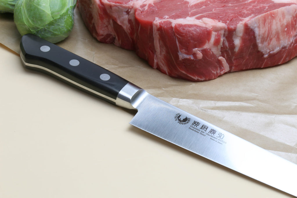 Sujihiki slicer chef knife with dark handle, stainless blade edge and bolster