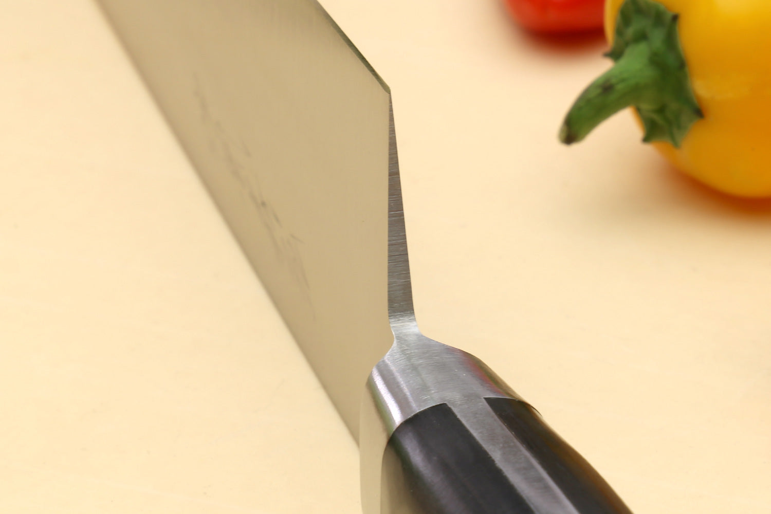 Double-edged deba fillet knife edge close-up, silver blade and dark handle