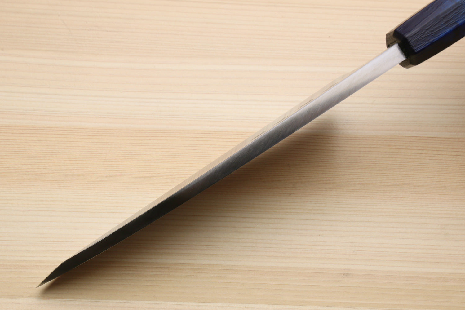 Japanese deba knife angled view with stainless blade and dark blue handle