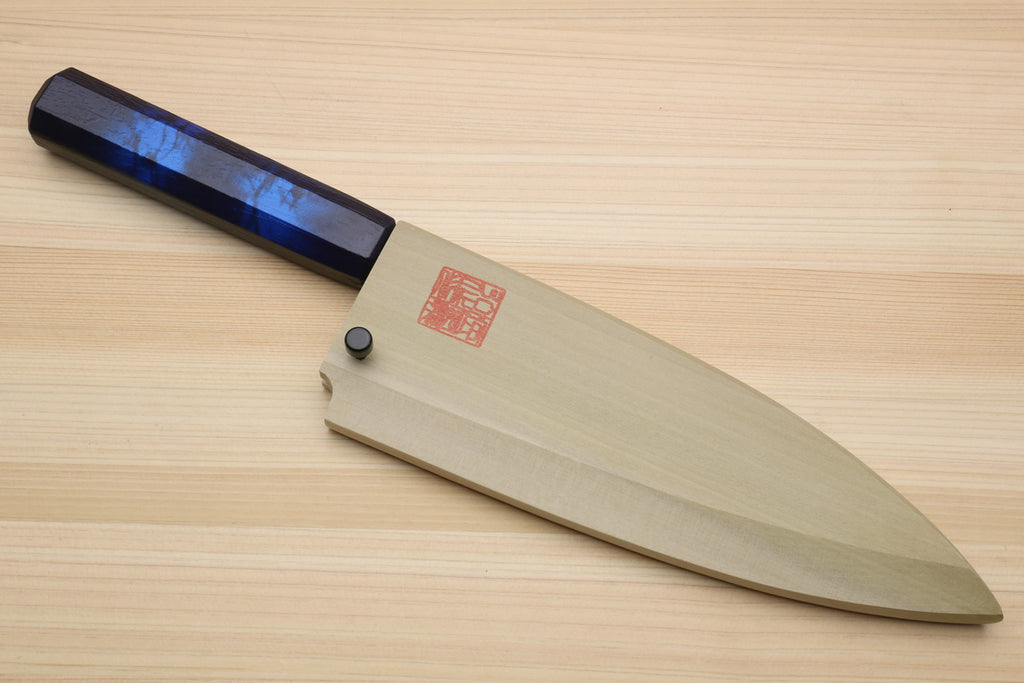 Japanese deba knife resting on wood with dark blue handle and stainless blade