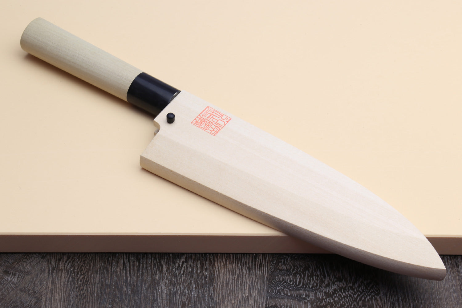 Deba fish fillet knife with white blade, light magnolia handle, and black ferrule