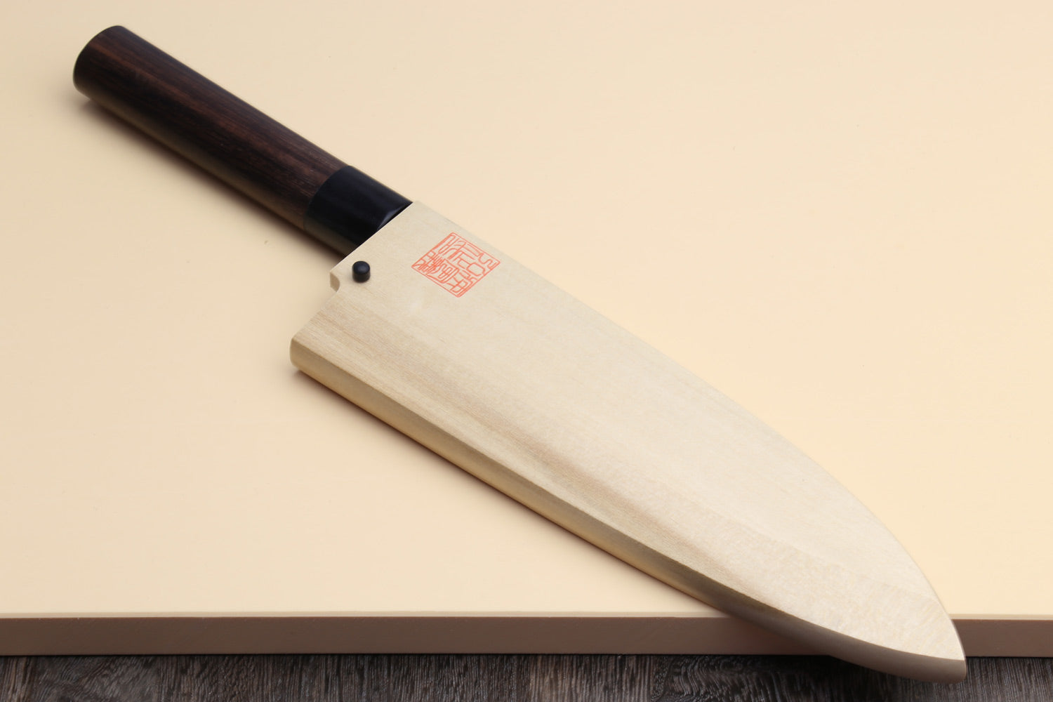 Deba knife with white blade, dark rosewood handle, and light protective sheath