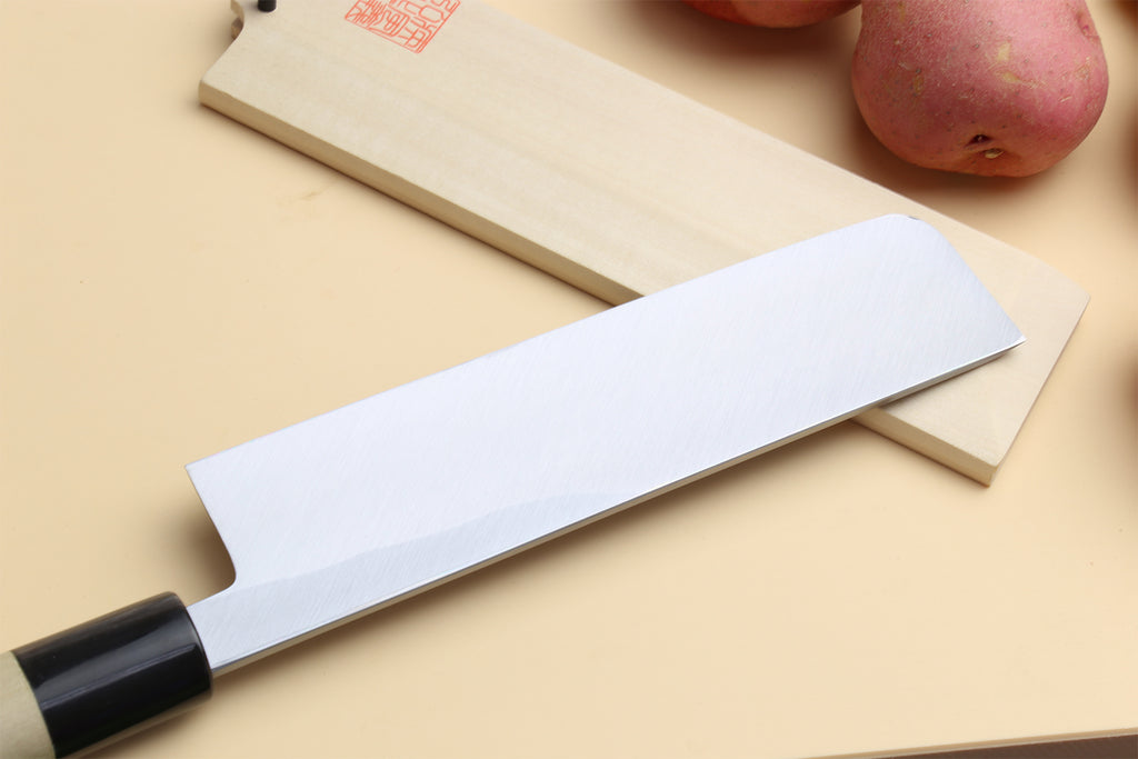 Japanese vegetable knife with pale handle and silver blade, cutting edge angled