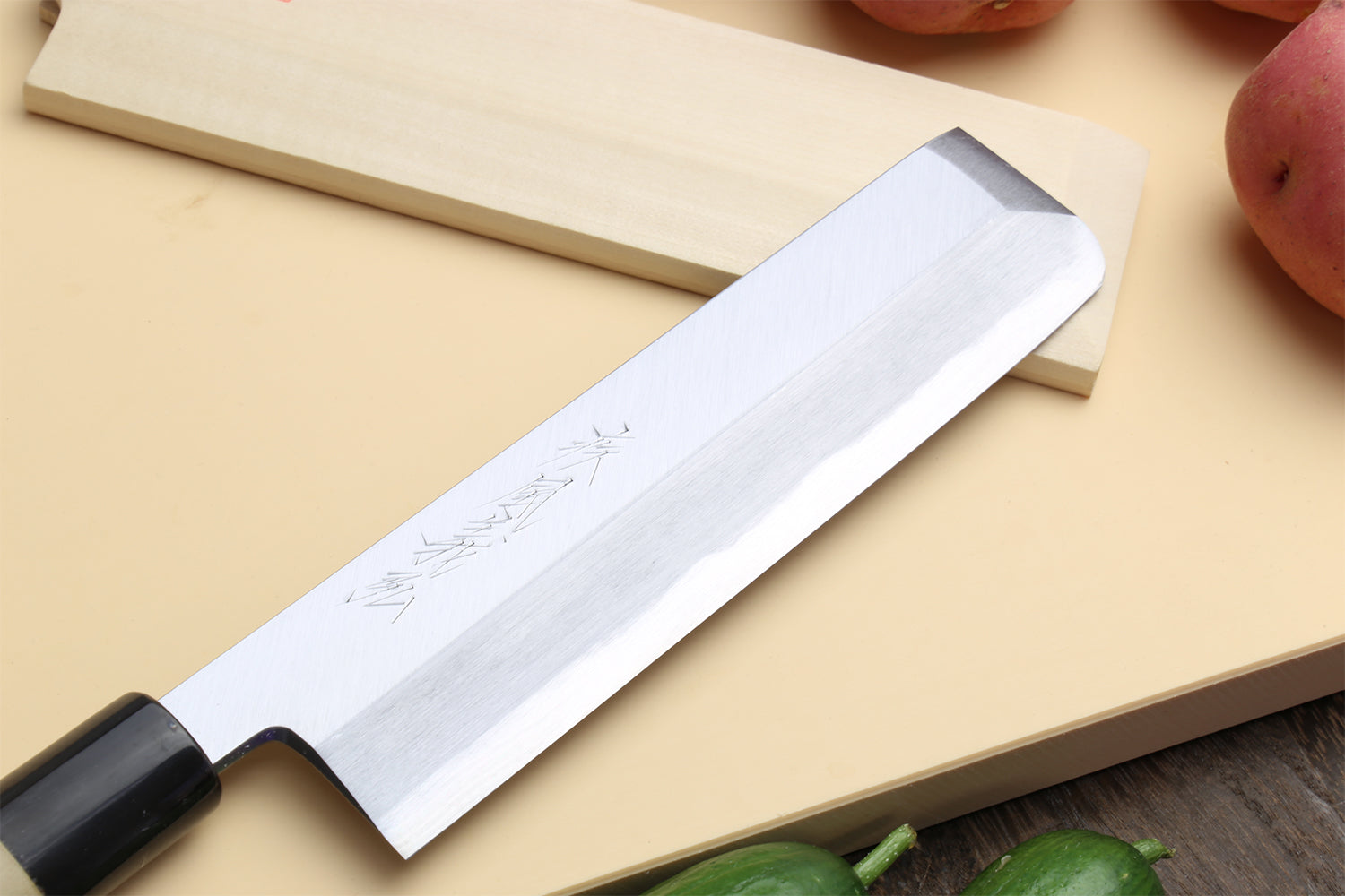 Japanese vegetable chef knife with light handle and silver blade, etched pattern visible