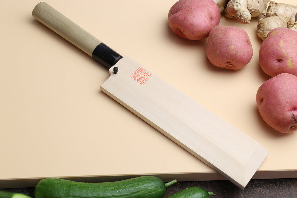 Japanese vegetable knife with light wood handle and dark collar, silver blade on surface