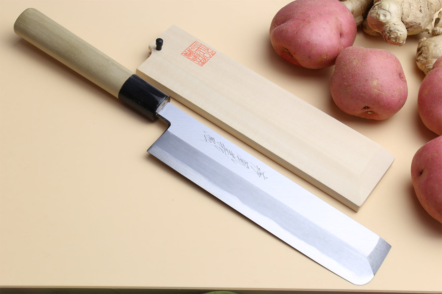 Traditional Japanese vegetable knife with light wood handle, dark collar, silver blade