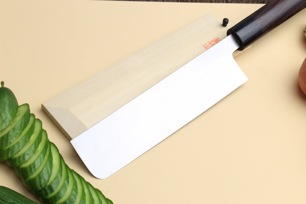 Traditional Japanese vegetable knife showing pale handle and white steel blade edge