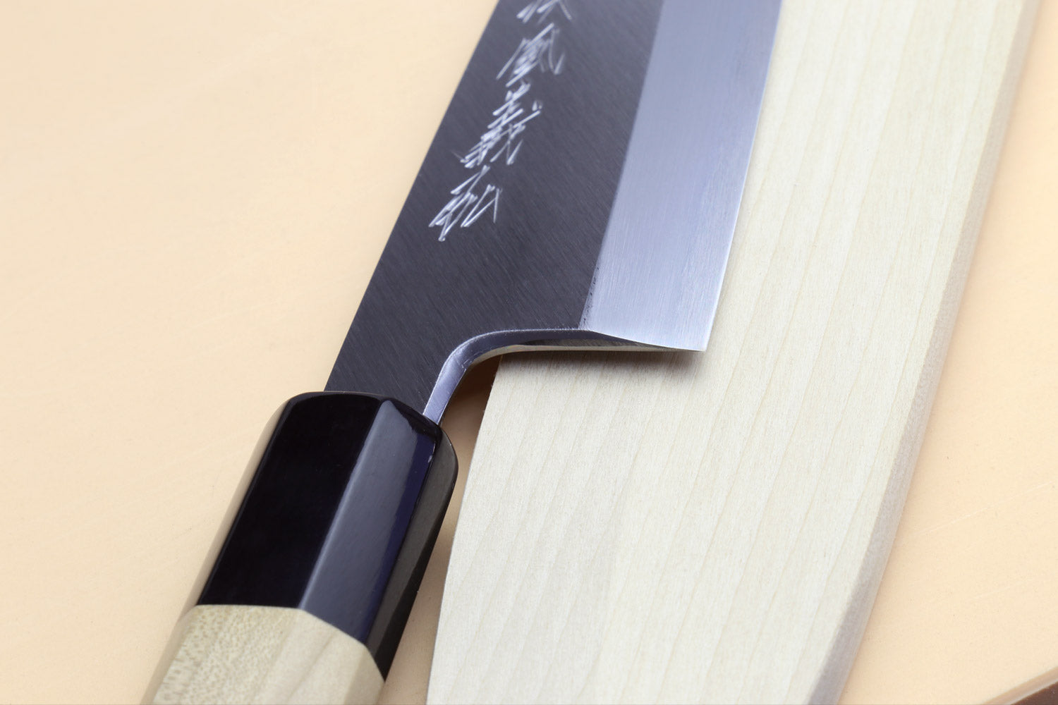 Fish fillet chef knife close-up of blade and light wood handle with dark bolster