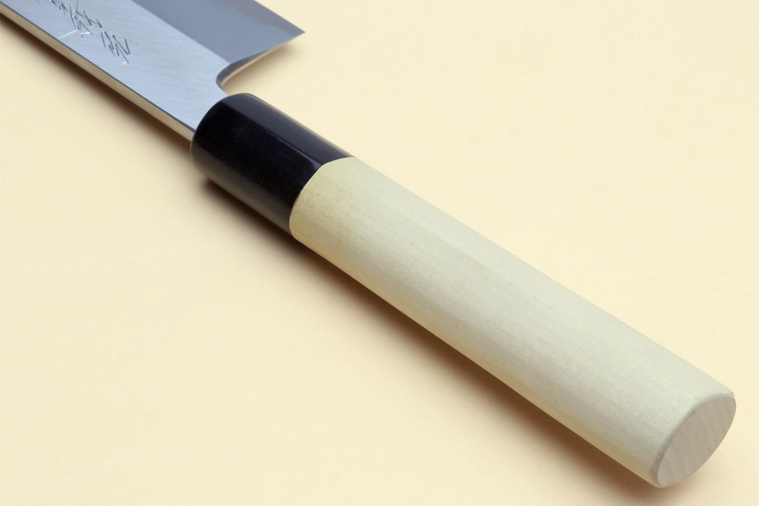 Japanese vegetable chef knife with light wood handle and dark blade, black end collar.