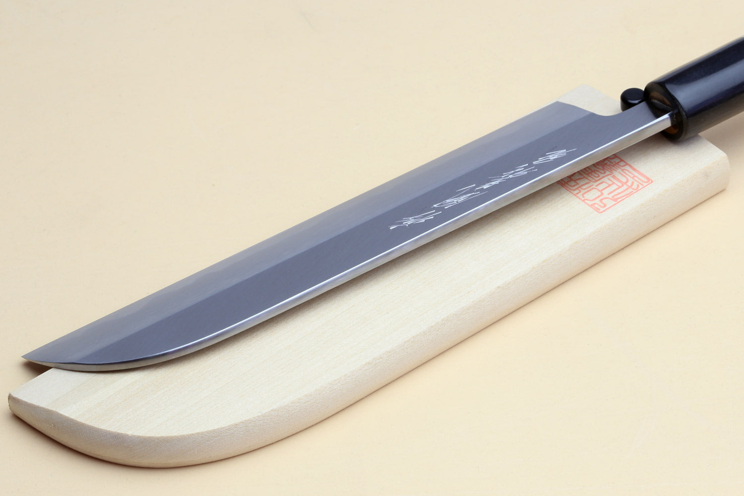 Japanese vegetable chef knife with dark steel blade and light wood handle, black collar.