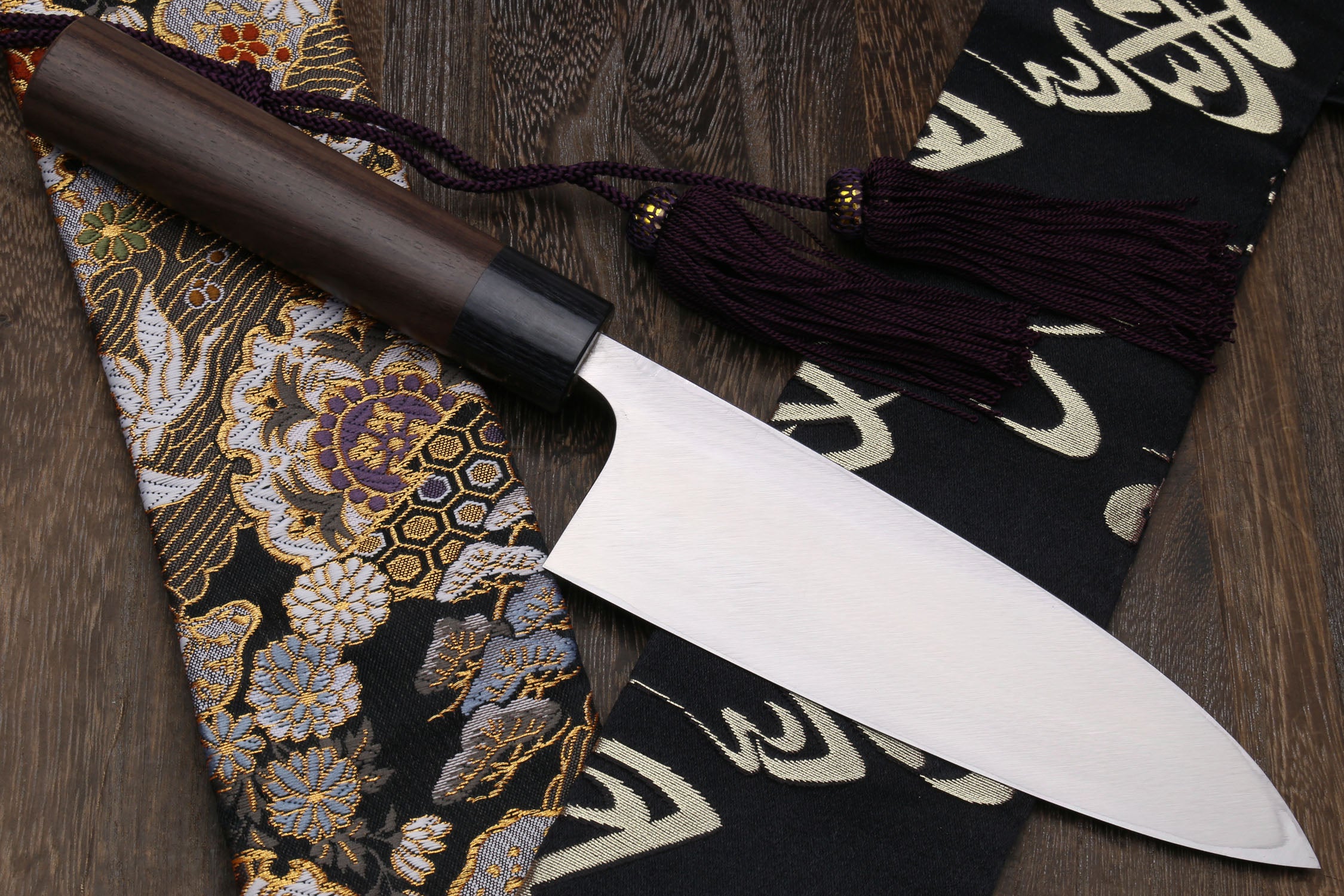 Left-handed deba fish fillet knife with white blade and dark shitan handle, side view