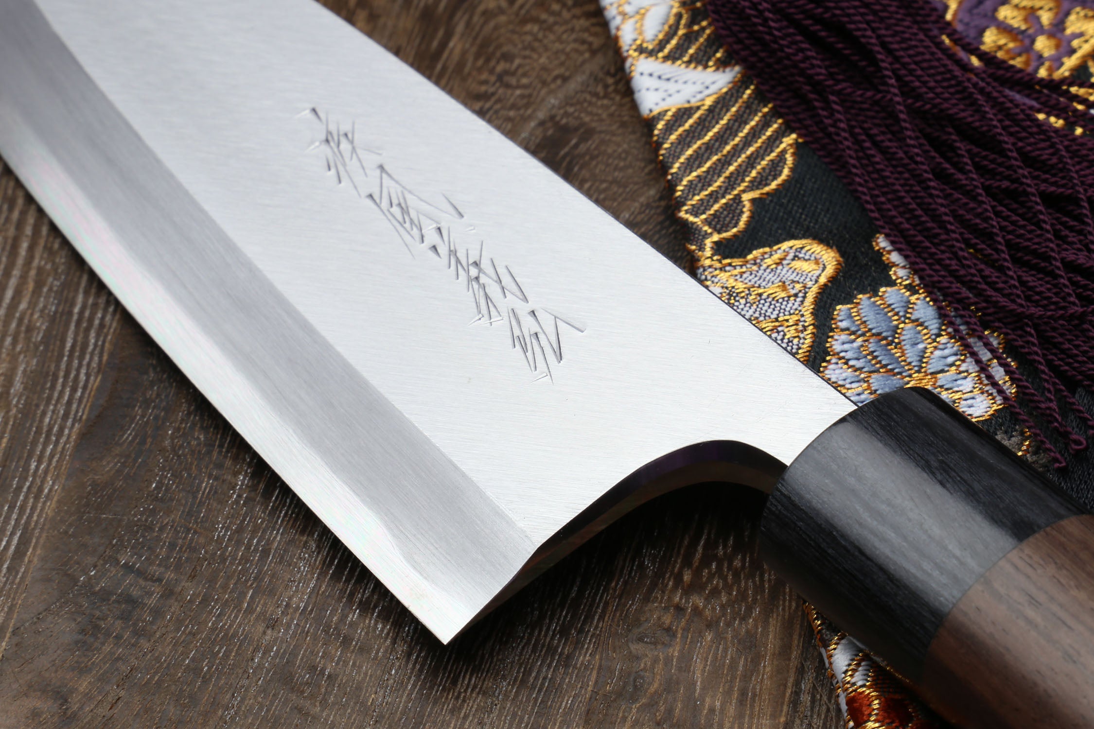 Left-handed deba fish fillet knife, white blade close-up with dark handle