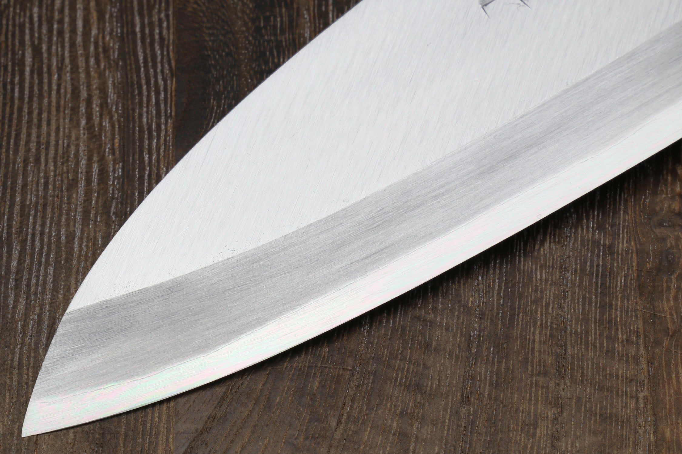 Left-handed deba fish fillet knife, white blade close-up and dark shitan handle