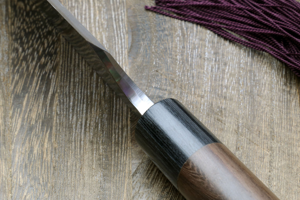 Left-handed deba fish fillet knife, dark handle and white blade detail