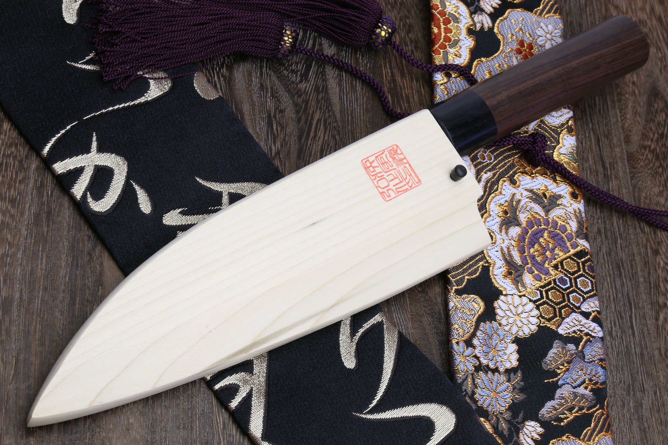 Left-handed deba fish fillet knife with white blade, dark shitan handle and cord grip