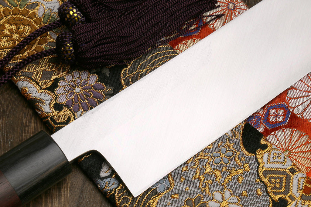 White steel vegetable knife with dark handle and tapered blade tip