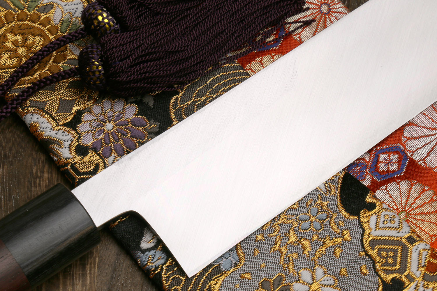 White steel vegetable knife with dark handle and tapered blade tip