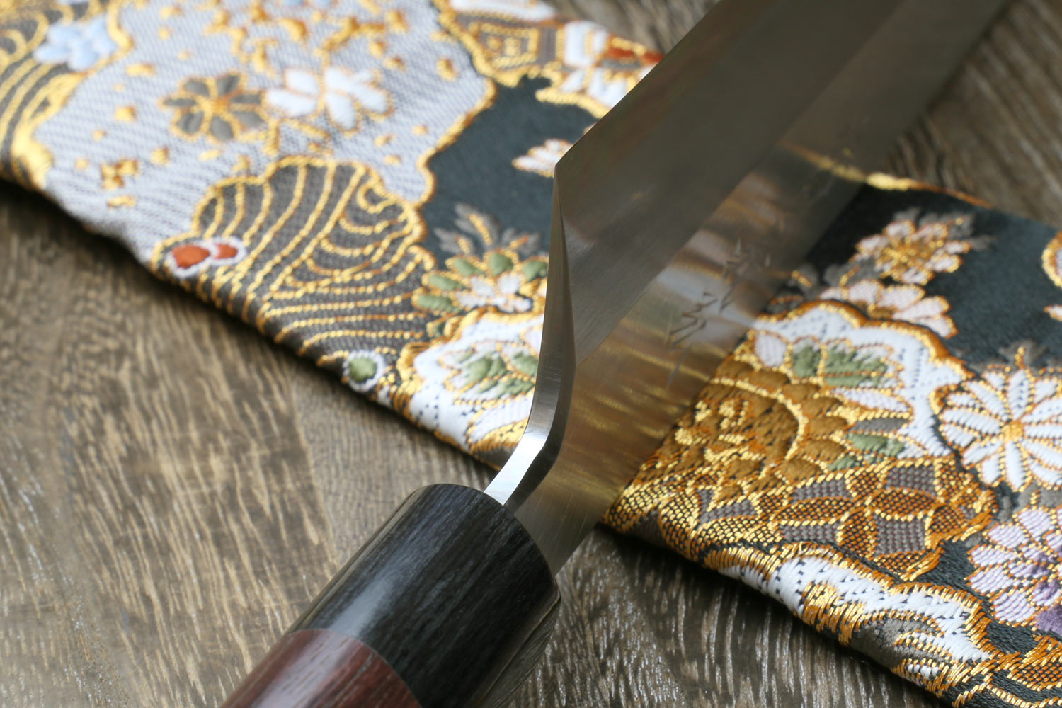 Traditional Japanese knife blade and dark shitan handle, showing edge and curve