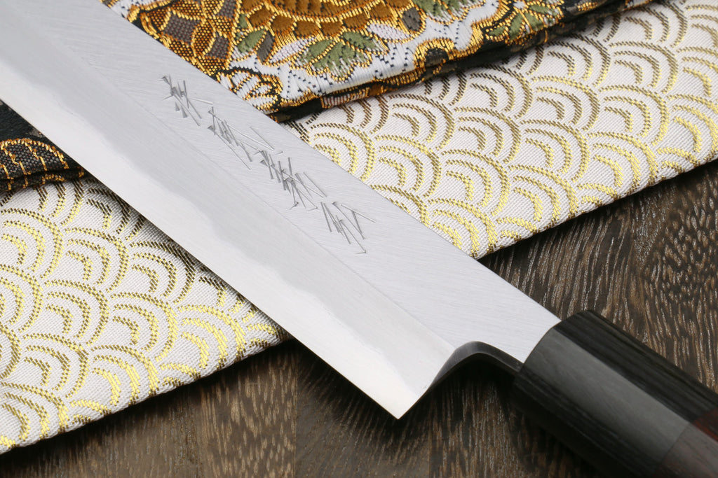 Yanagi knife blade close-up on white steel with engraved markings