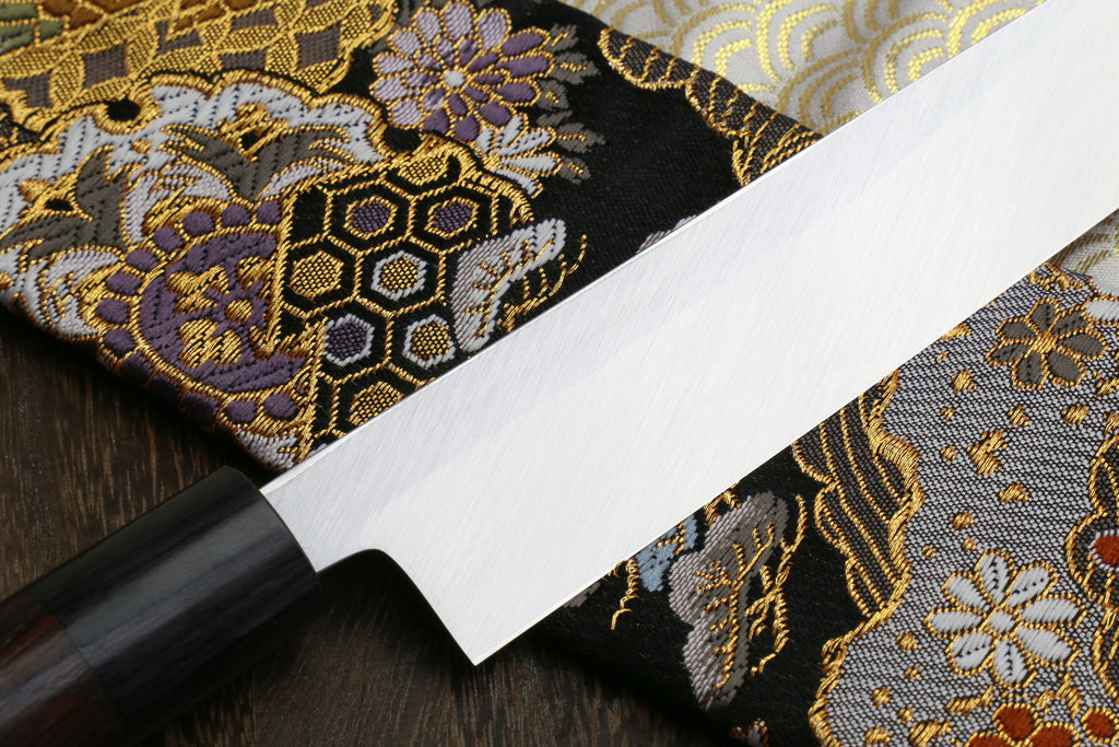 Yanagi knife with white steel blade and dark Shitan handle, angled view