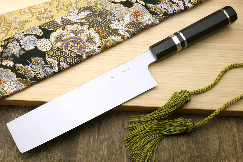 Japanese vegetable knife with dark checkered handle sleeve, polished blade on cloth