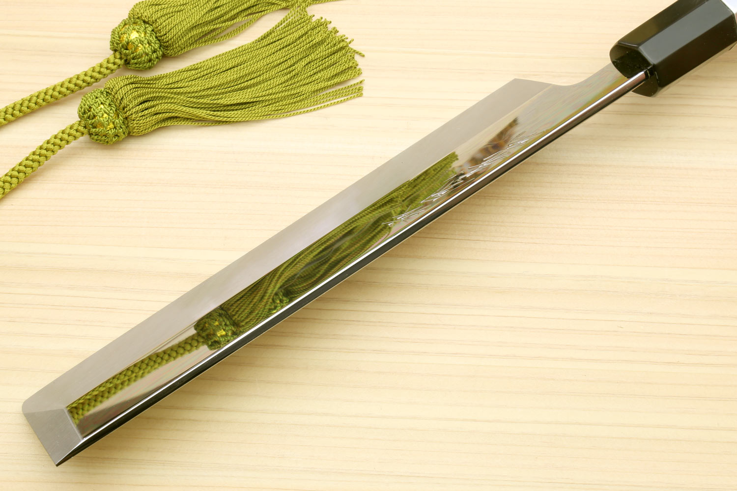 Japanese vegetable knife with mirror edge and dark handle, full length on wood