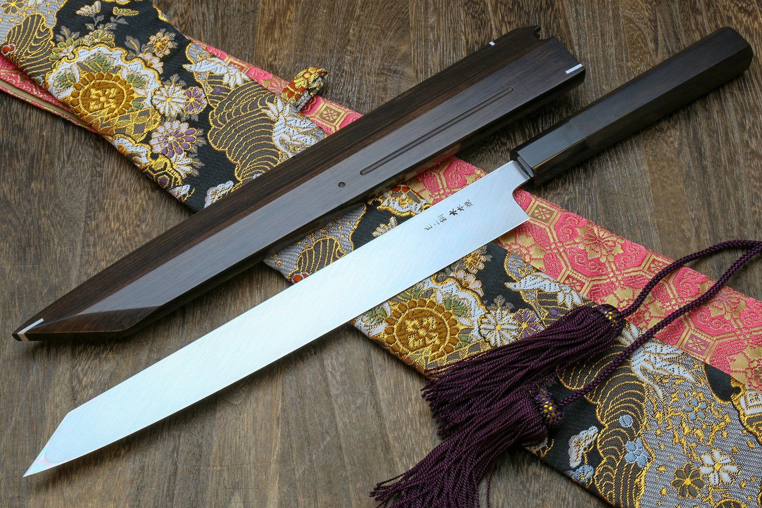 Japanese sushi knife with long mirror-finished white steel blade in black saya