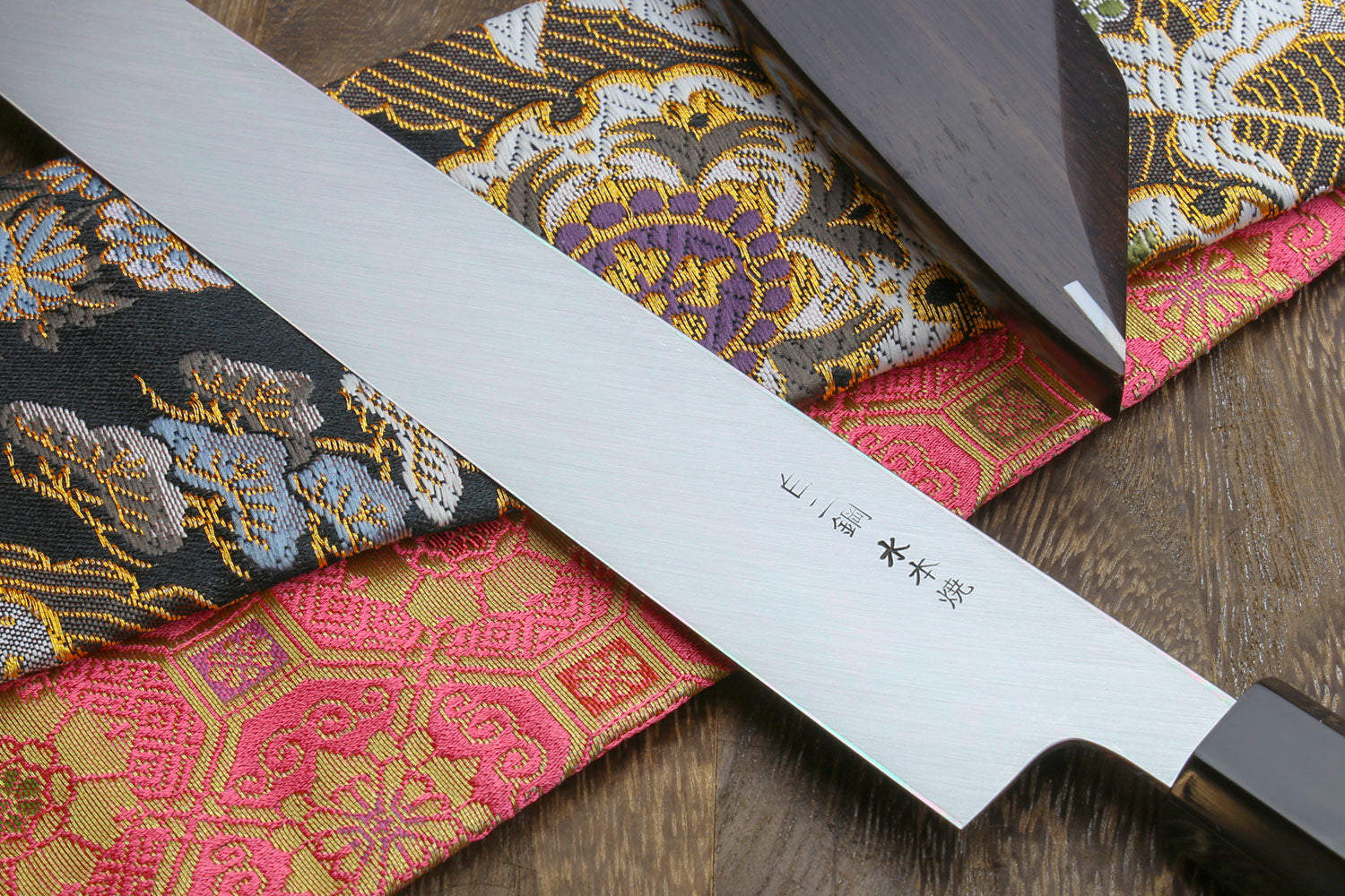 Japanese sushi knife blade close-up with mirror finish and engraved marks