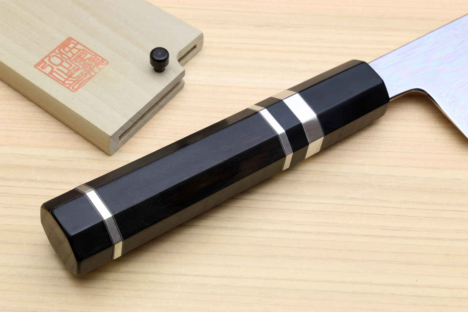 Japanese chef knife with black handle, white stripe, and silver ring