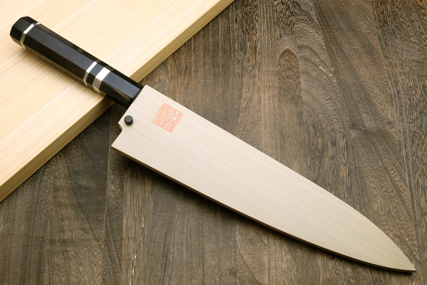 Japanese chef knife with white-striped ebony handle and mirror-polished blade