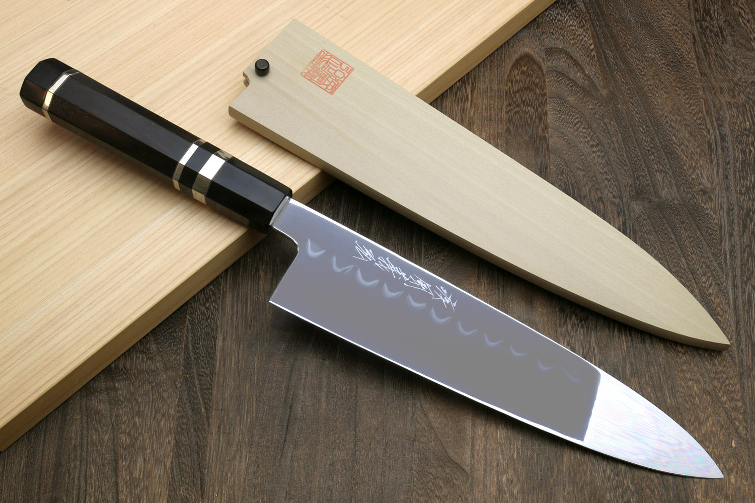 Japanese chef knife with mirror-polished blade, wavy hamon, and black handle