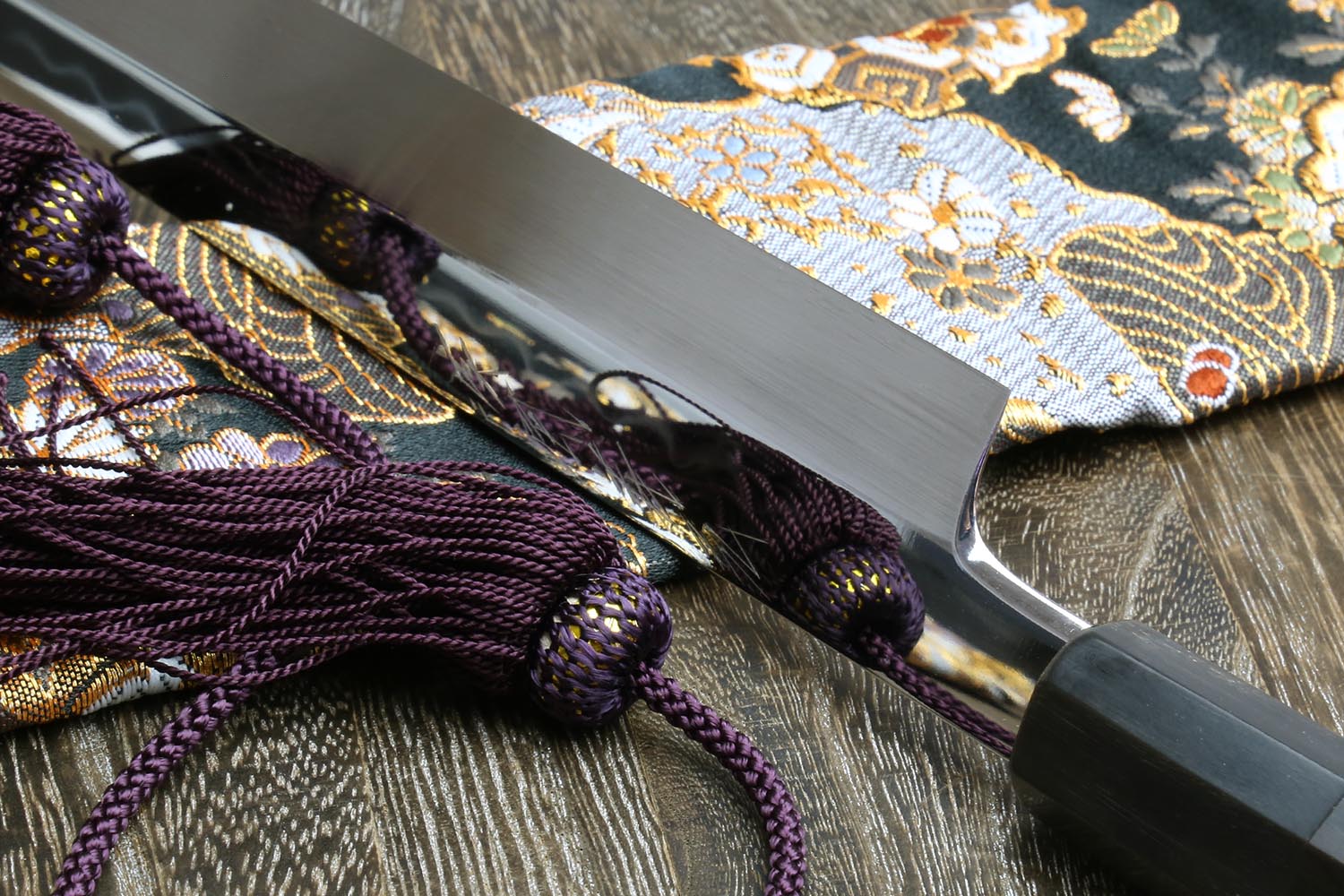 Yanagi knife blade close-up, mirror-finished white steel with decorative etching