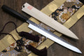 Yanagi knife on patterned fabric with tassel ties, white blade and dark handle